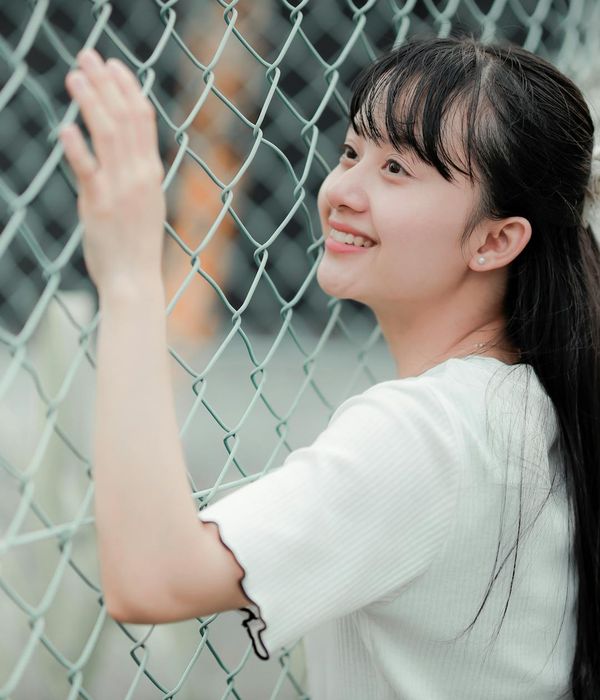 Person smiling and looking energetic outdoors in a natural park setting.